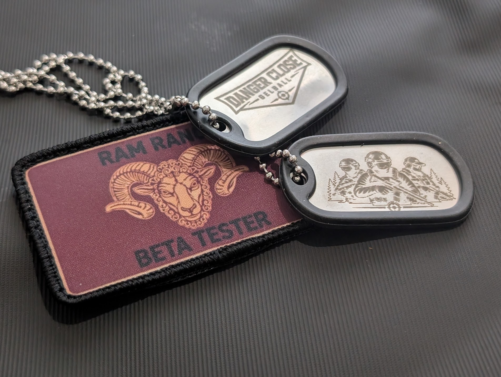 The Ram Ranch Beta Tester patch beside two engraved Danger Close Gelball dog tags